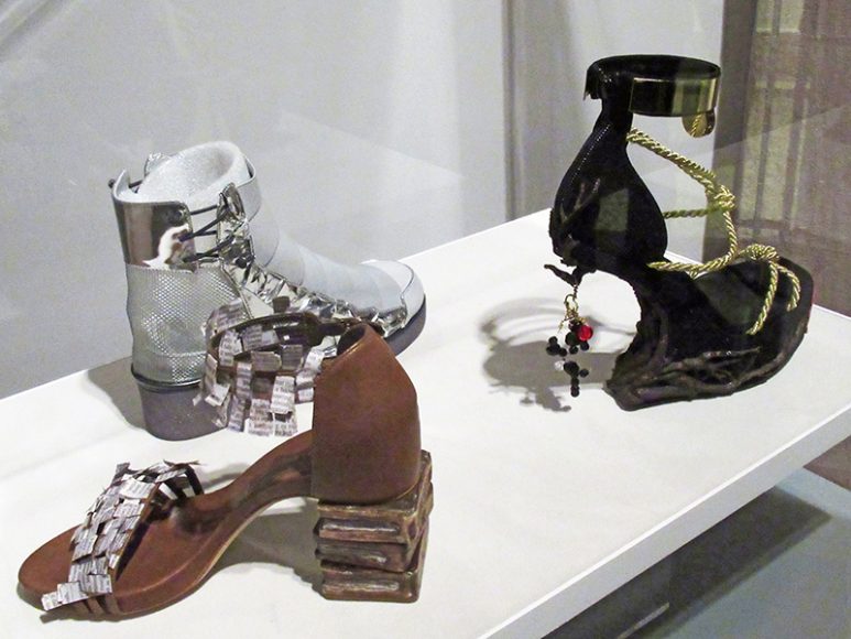 In 2017, Stuart Weitzman and the New-York Historical Society sponsored a design competition for high school students in the tri-state area, with the winning designs in both categories fabricated by Stuart Weitzman. They include the two designs that tied for top honors in the Socially Conscious Fashion division (“Empowerment” by Samantha Efobi of Byram Hills High School, the brown-hued model in forefront, and “Veni. Vidi. Vici.” by Alivia Matthews of the High School of Art and Design, the black-and-gold shoe at right), while Danielle Fliegel of Byram Hills High School’s “Ziggy,” the silver shoe in rear, took the prize for Material Innovation. Photograph by Mary Shustack.