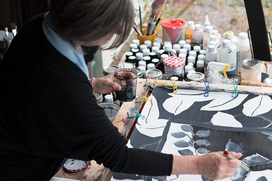 To help the process, Worby uses a mechanism that simultaneously stretches and holds the fabric in place while she paints.  Photograph by Elijah Riess.