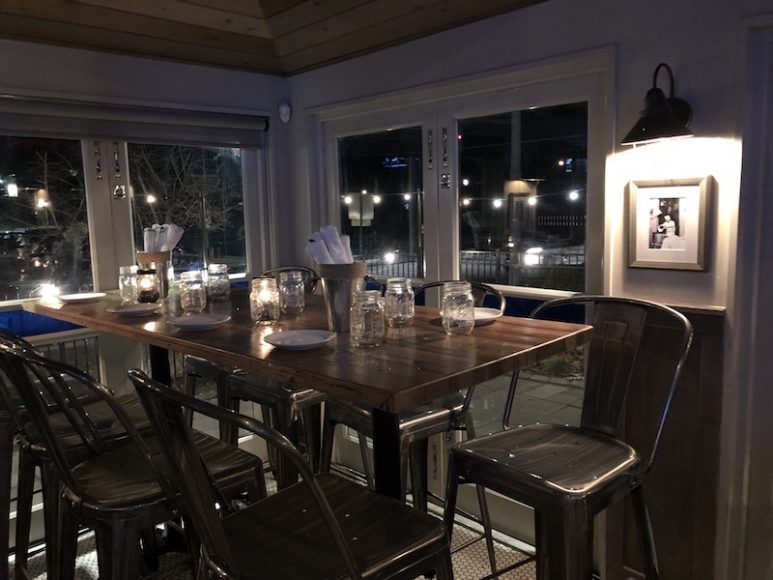 The restuarant features industrial fixtures and metal chairs.