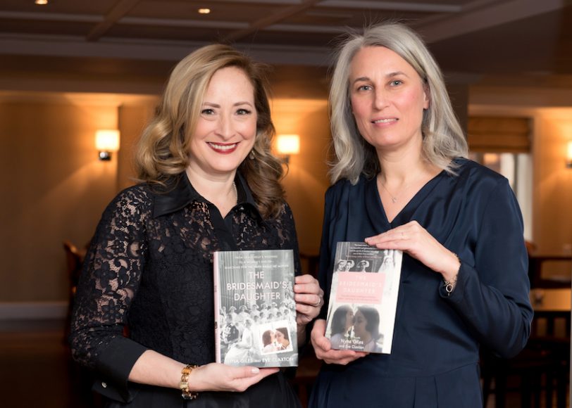 Nyna Giles (black lace) and Eve Claxton (blue dress) with copies of their book “The Bridesmaid’s Daughter.” Photograph by Lynda Shenkman.