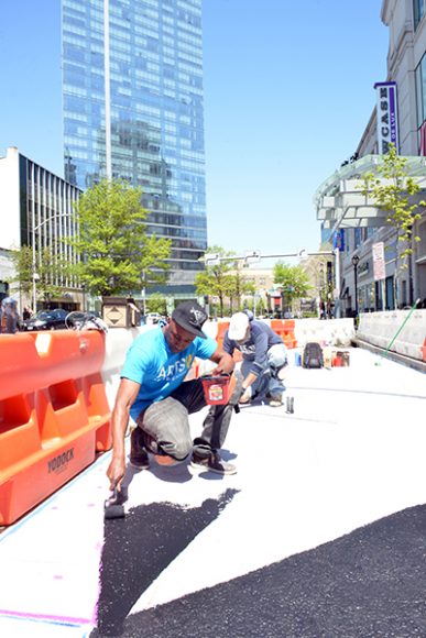 Wane One working on his mural “Brighter Colors Better Life,” outside ArtsWestchester’s Arts Exchange headquarters at 31 Mamaroneck Ave. in White Plains. Photograph by Bob Rozycki.