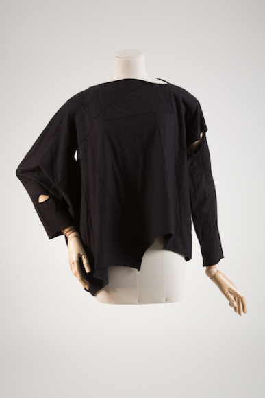 Comme des Garçons, T-shirt, cotton knit, 1983, Japan. The Museum at FIT, 90.98.69, gift of Ms. Terry Melville. Photograph © The Museum at FIT. This early Comme des Garçons T-shirt is constructed from asymmetrical pieces of black knit, haphazardly assembled and resulting in the gaps and unfinished edges that were integral to the brand’s aesthetic.