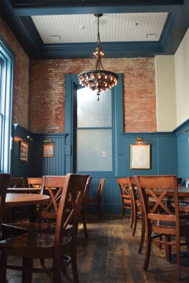 A separate dining area features historical prints and industrial fixtures.