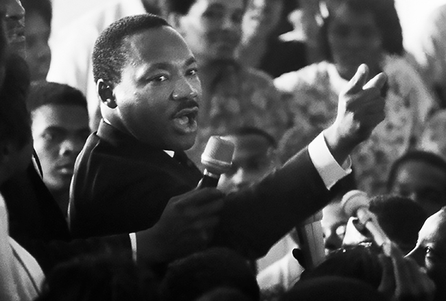 : The Rev. Dr. Martin Luther King Jr. arriving in the Watts section of Los Angeles after the 1965 riots. Photograph by Lawrence Schiller. Courtesy of the Lawrence Schiller Archives.