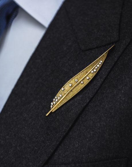 An elegant gold leaf brooch scattered with round brilliant-cut diamonds by Pierre Sterlé (circa 1950). Courtesy Hancocks. Tailoring by Henry Poole & Co.