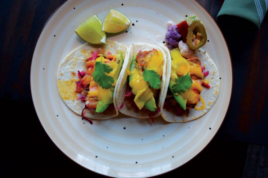 A trio of salmon tacos are drizzled with mango habanero salsa.