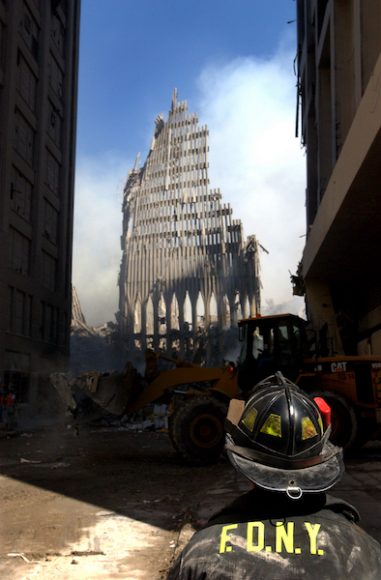A New York City firefighter looks on at the skeletal remains of the South Tower.