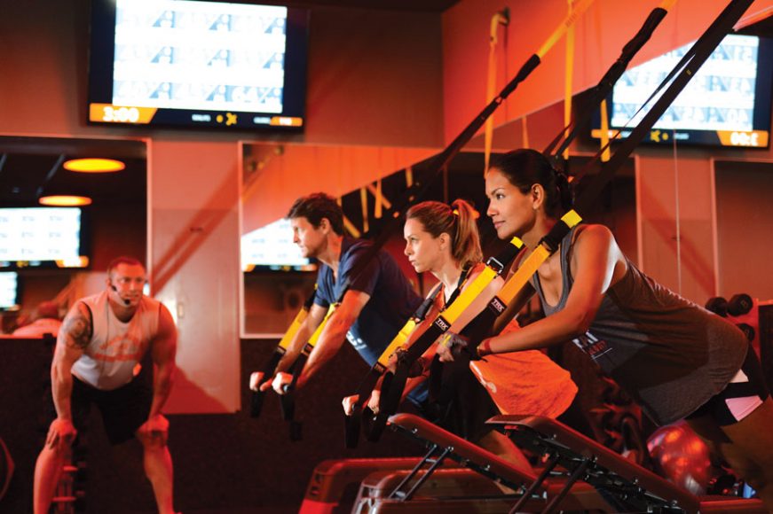 Orange Theory classes involve cardio and strength training. Clients use TRX suspension training to build strength. Photographs courtesy of Orange Theory White Plains.