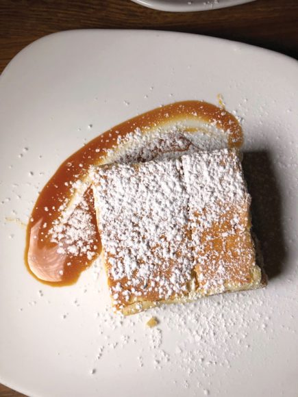 Cheesecake sits atop a caramel sauce.