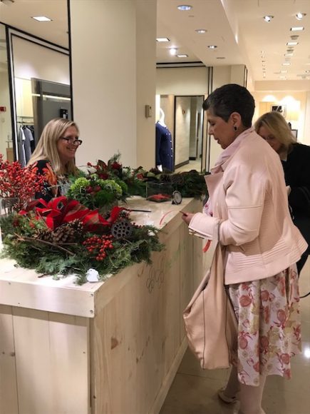 Robin Costello (far right) and Georgette Gouveia of WAG check out the holiday offerings from The Flower Bar in Larchmont. 