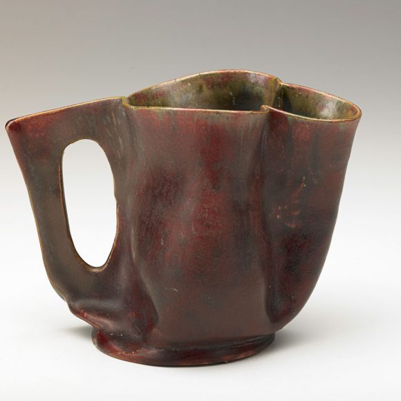 Pitcher with cutout handle, deep matte red glaze (1900s), sold for $11,875 (estimate $5,000-$7,500). Courtesy Rago Arts and Auction.