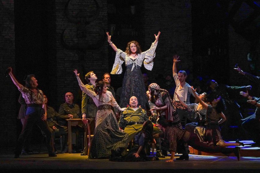 Clémentine Margaine (center, with Raymond Aceto as Zuniga, below) as the title character in the tavern scene from “Carmen.” Karen Almond/Met Opera.