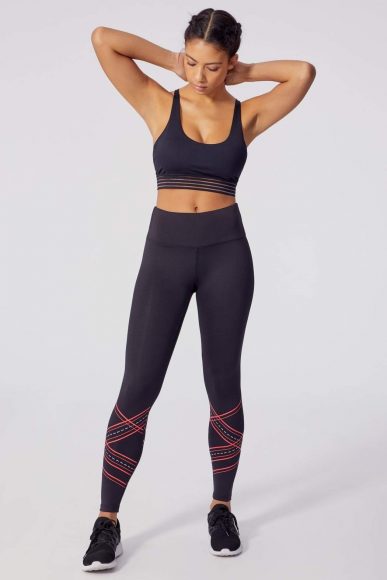 Black sports bra with mesh band detail and black leggings with coral detail from January’s Knot Your Average collection.