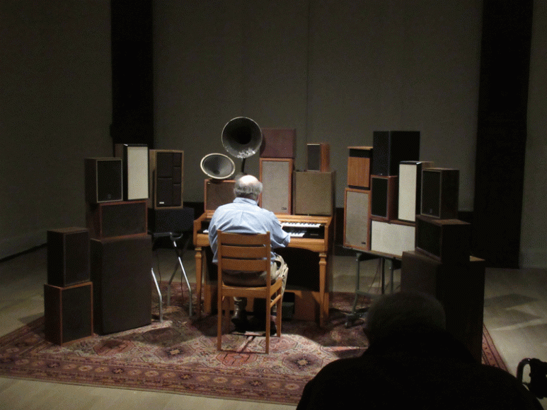 A gentleman attending the April 9 press preview of “Leonard Cohen: A Crack in Everything” at the Jewish Museum in Manhattan tries out “The Poetry Machine,” a 2017 interactive audio/mixed-media installation by Janet Cardiff and George Bures Miller. When an organ key is pressed, the room is filled with Cohen’s voice reading his own words from 2006’s “Book of Longing.” Photograph by Mary Shustack.
