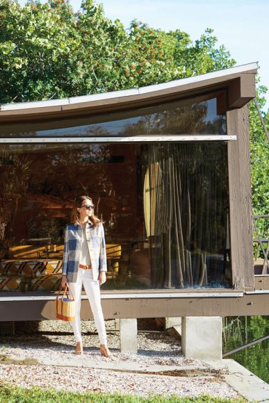 A model in the must-have Hester Coat is photographed in front of the iconic Cocoon House on Siesta Key in Sarasota, Florida. The house was designed by Paul Rudolph in 1950. Add the soft Henri sweater, white Lexi jeans, Ruby reversible belt, tortoise sunglasses and chic wicker bag for the ultimate spring ensemble. Photograph courtesy J. McLaughlin.
