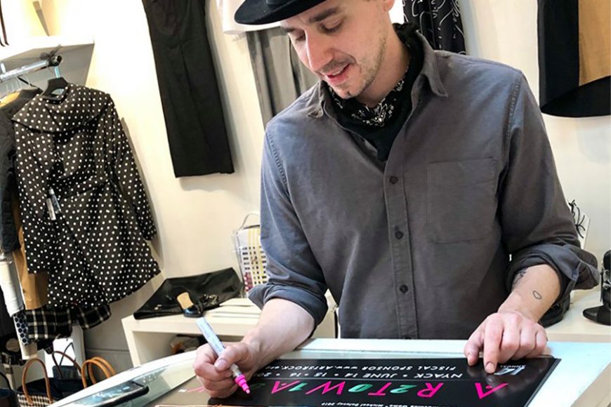 Artist Michael Delaney signs the limited-edition ART WALK poster, gearing up for the June 14-16 event. Courtesy Nyack ART WALK/Facebook.