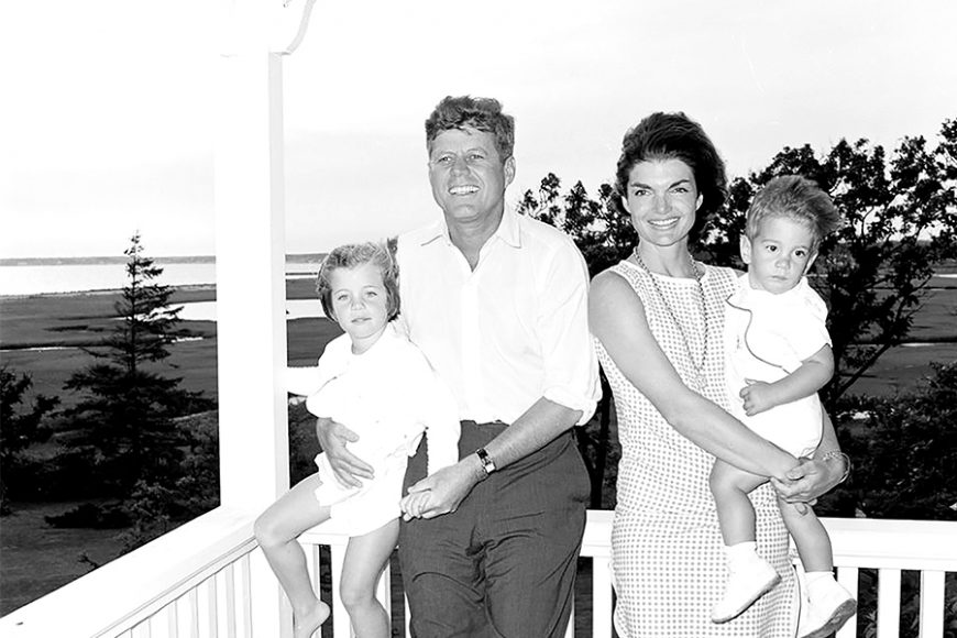 President John F. Kennedy and first lady Jacqueline Kennedy pose for a portrait with their children, Caroline Kennedy and John F. Kennedy Jr., on a porch in Hyannis Port, Massachusetts. Courtesy Cecil Stoughton. White House Photographs. John F. Kennedy Presidential Library and Museum, Boston.