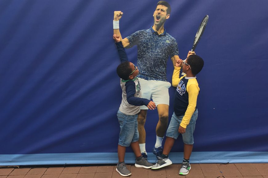 Two young fans pose with an image of Novak Djokovic, last year’s men’s singles champion at the US Open.