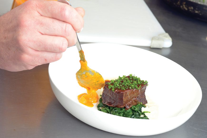 Andrew Cain prepares a test meal of braised boneless beef short rib, Yukon Gold mashed potatoes, sweet carrots and their puree with red wine braisage reduction sauce. Photograph by Bob Rozycki.