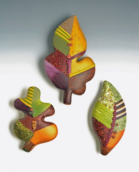 A trio of leaf brooches, 4 to 5 inches in length, are hand-sculpted leaf forms veneered with patterns made in the millefiori process. Photograph by Bob Barrett. Courtesy Loretta Lam.