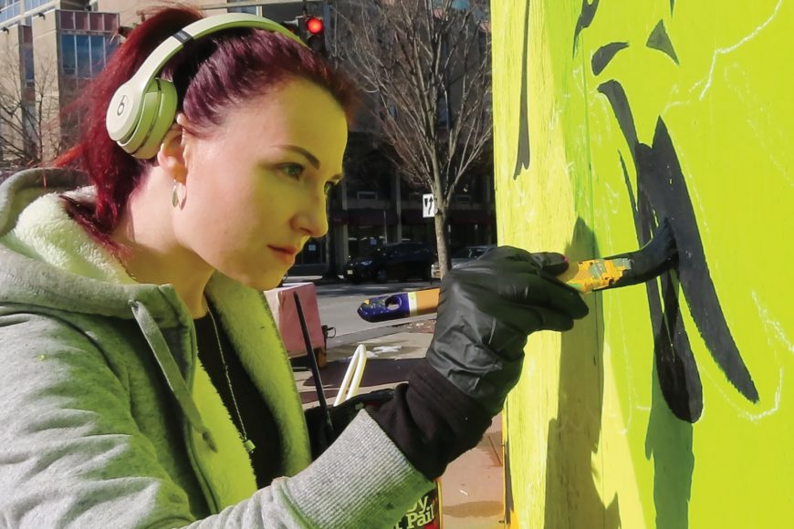 Artist Oscar Lett at work on a street mural in White Plains. Photograph by Will Bermingham (2019).
