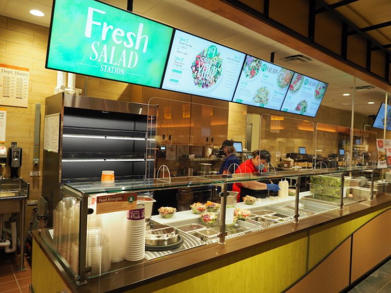 Workers prepare bowls at the Fresh Salad Station.