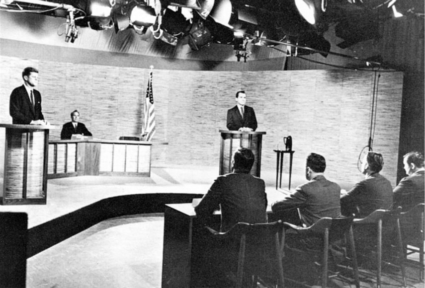 Sen.John F.Kennedy (at left podium) and Vice President Richard M.Nixon (at right po¬dium) in the third of four presidential debates, the first ever in the history of the American presidency, at NBC studios in Washington, D.C., Oct. 7, 1960, At center rear is moderator Frank McGee of NBC. The four news men who asked the questions are, left to right: Hal Levyof Newsday; Alvin Spivak of United Press International; Edward P.Morgan of ABC; and Paul Niven of CBS. Courtesy UPI.