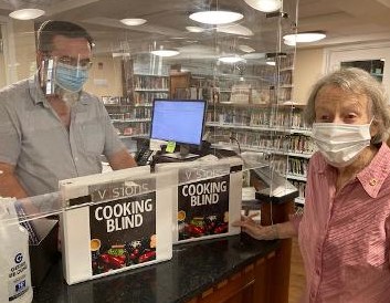 Larchmont Mamaroneck Lions Club member Peggy Rao presents “Cooking Blind & Sighted” to Frank Connelly of the Larchmont Public Library. Courtesy Larchmont Mamaroneck Lions Club.
