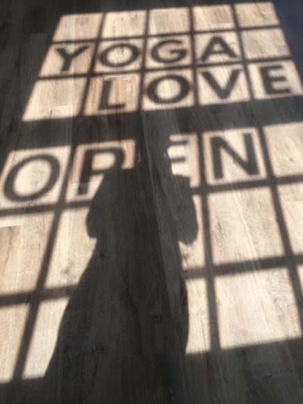 The editor catches a silhouette of herself in the shadow of the Yoga Love NY sign.